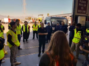 A group of people standing in front of a truck in the Velocity Truck centers facility.