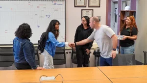 A group of people shaking hands in a conference room during the Wing-EV event.