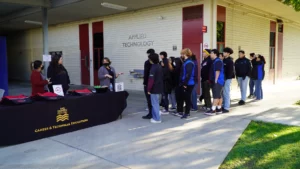 Students lining up at an information booth for applied technology careers and technical education.