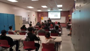 An instructor giving a presentation to a classroom of attentive students.