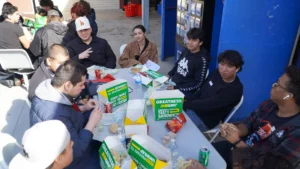 A group of people enjoying a meal together outdoors at a casual gathering.