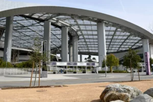 Modern stadium with a large, curved canopy structure and surrounding landscaping.