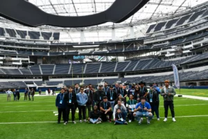 Group of people posing for a photo on a stadium field.