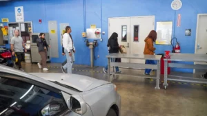 Customers waiting in line at a vehicle inspection station.