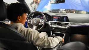 Person in the driver's seat of a bmw, interacting with the car's touchscreen interface.