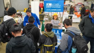 People gathered around a booth for the Los Angeles Department of Water and Power at an event, with a banner promoting job opportunities visible.